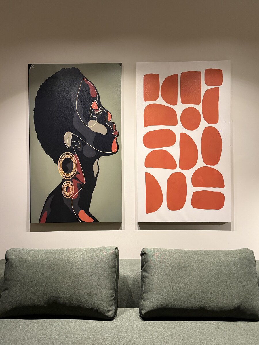 Custom artwork above the olive-green sofa