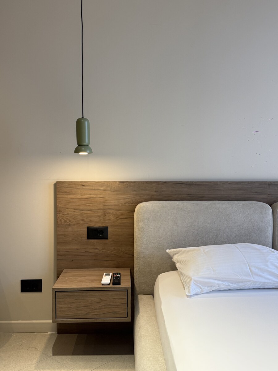 Double bed with an oak headboard and pendant reading light